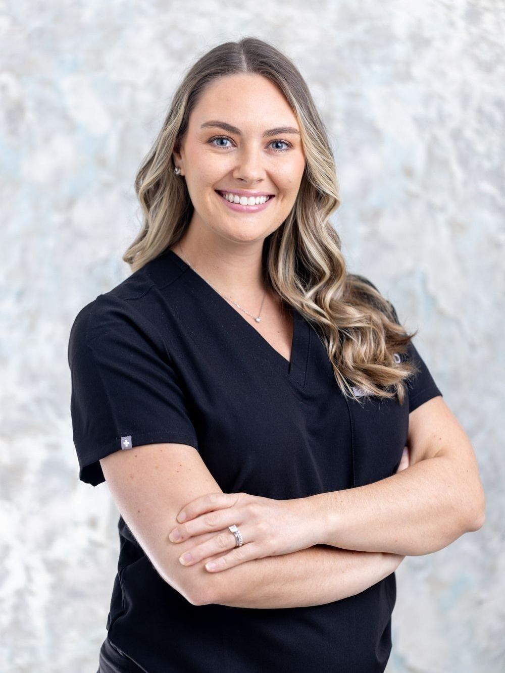 aesthetic physician associate brook buchanan smiling in her scrubs