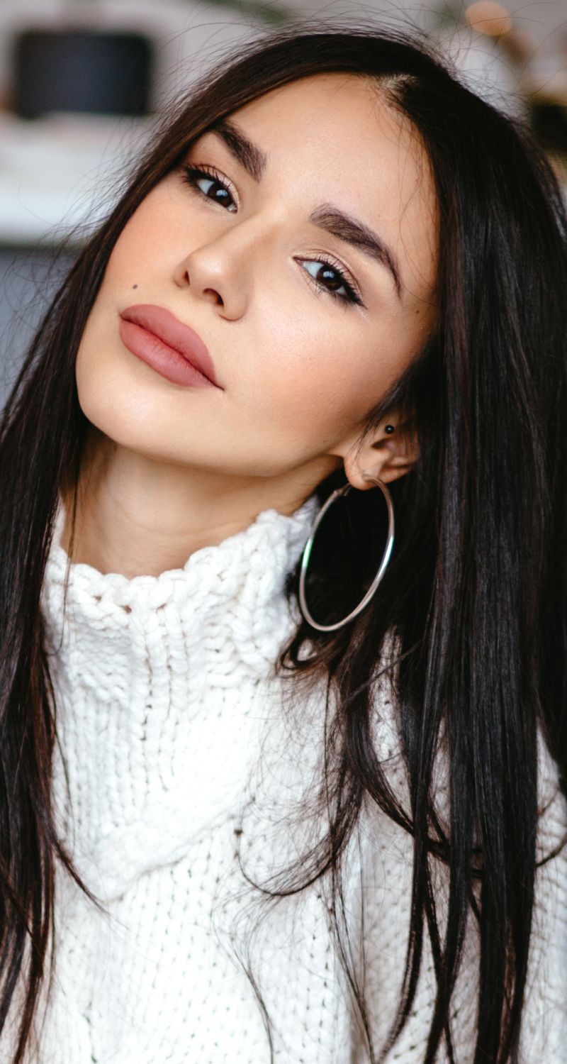 Woman with long hair in cozy sweater.