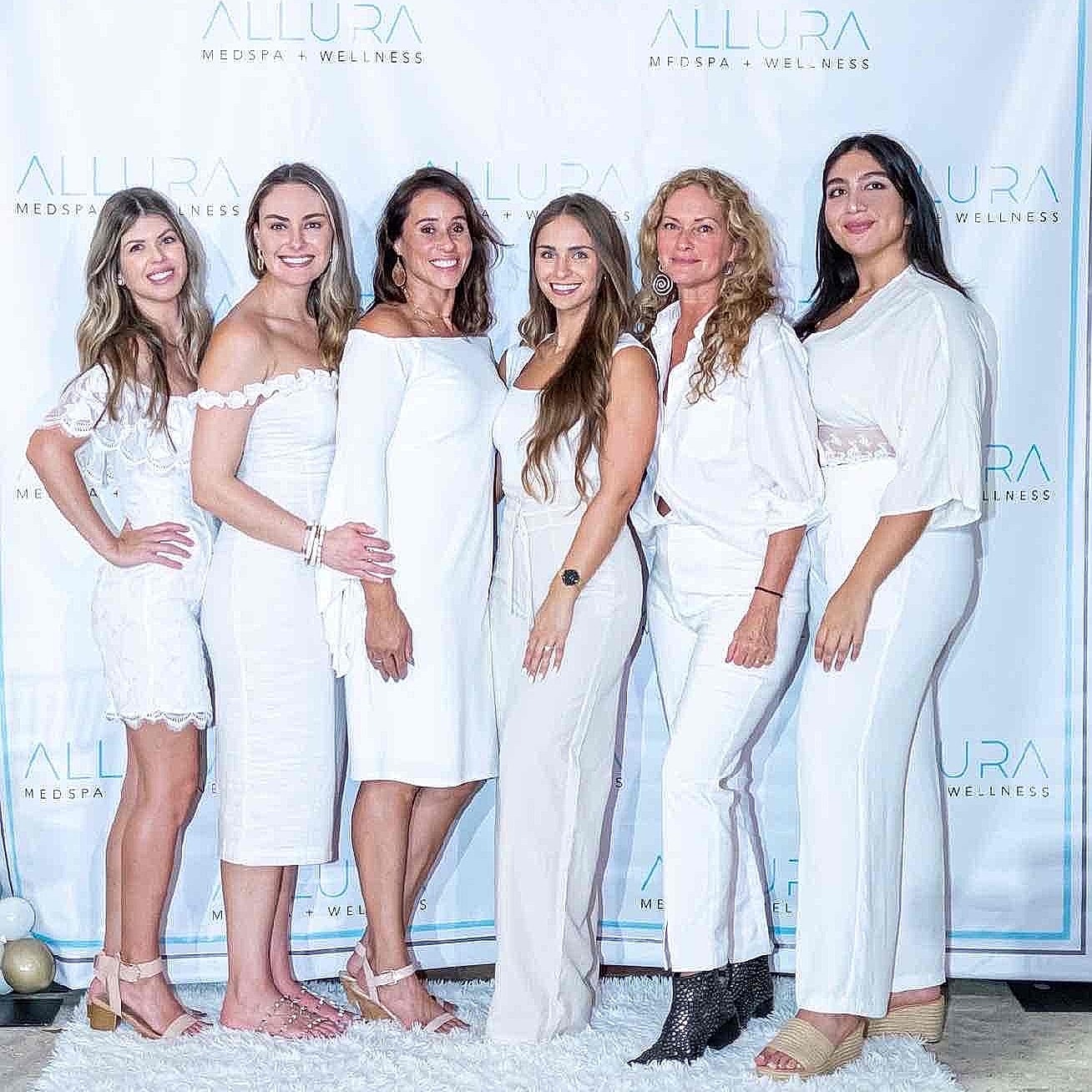 Women in white outfits at an event.