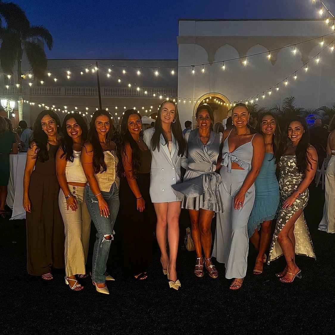 Group of women smiling at evening event.