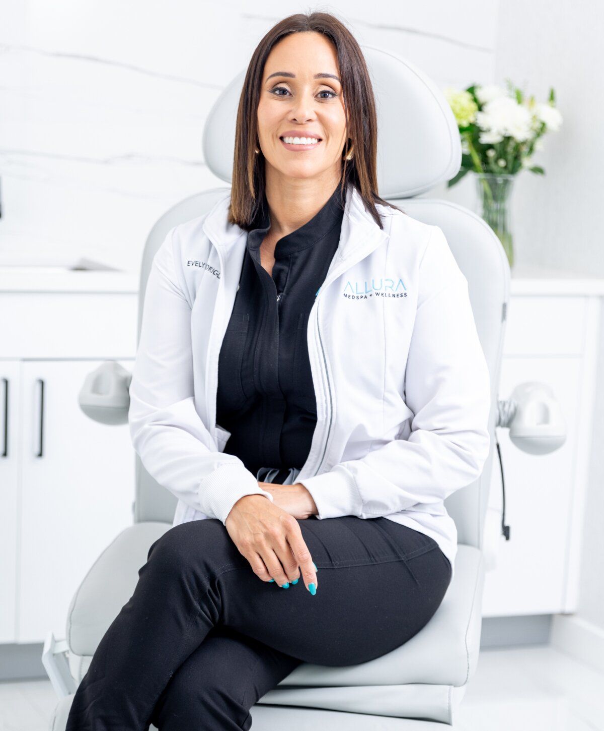alluramd founder evelyn rodriquez smiling in a clinical setting.