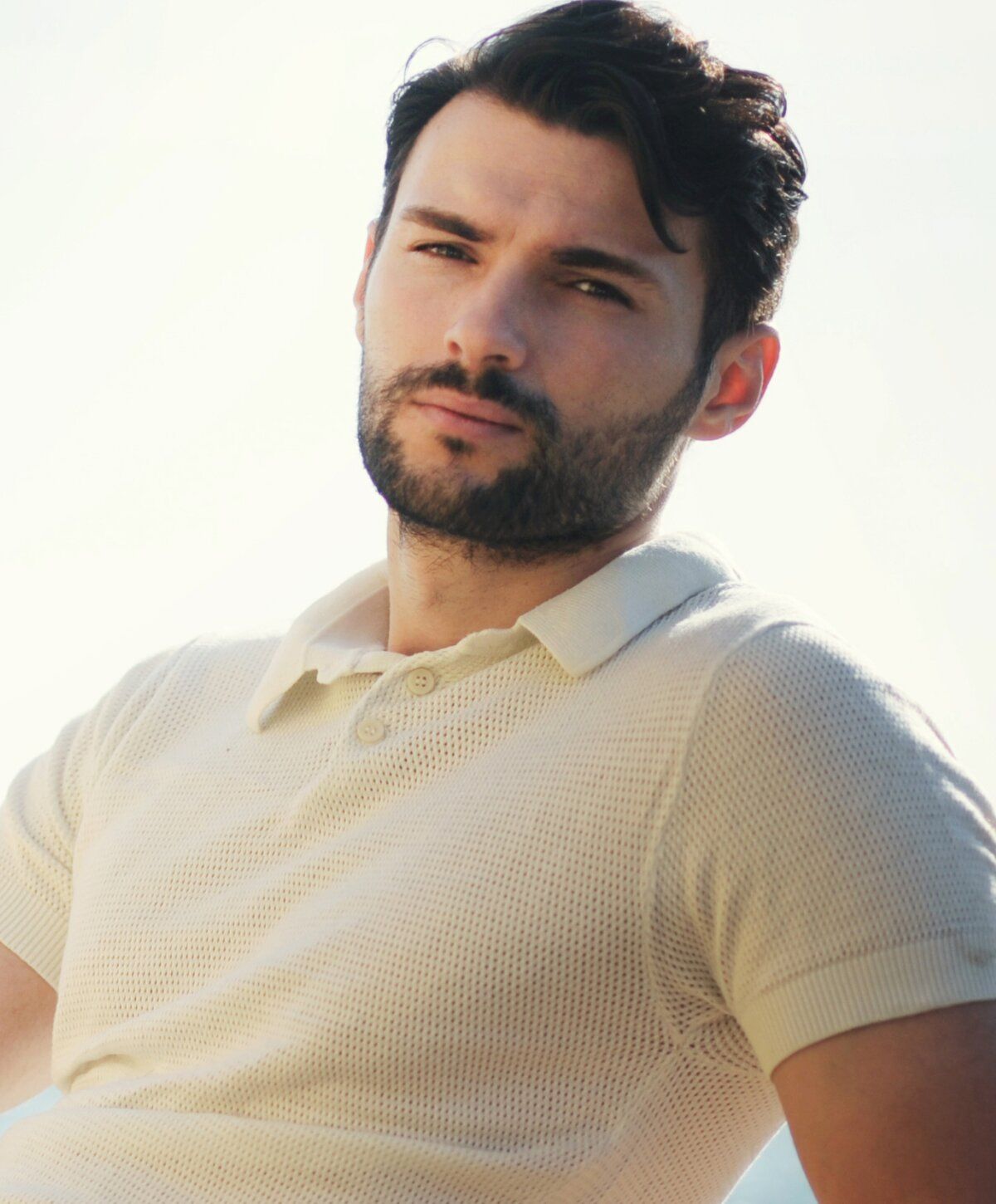 Male hair restoration with growth factors patient model with beard in casual white polo shirt.