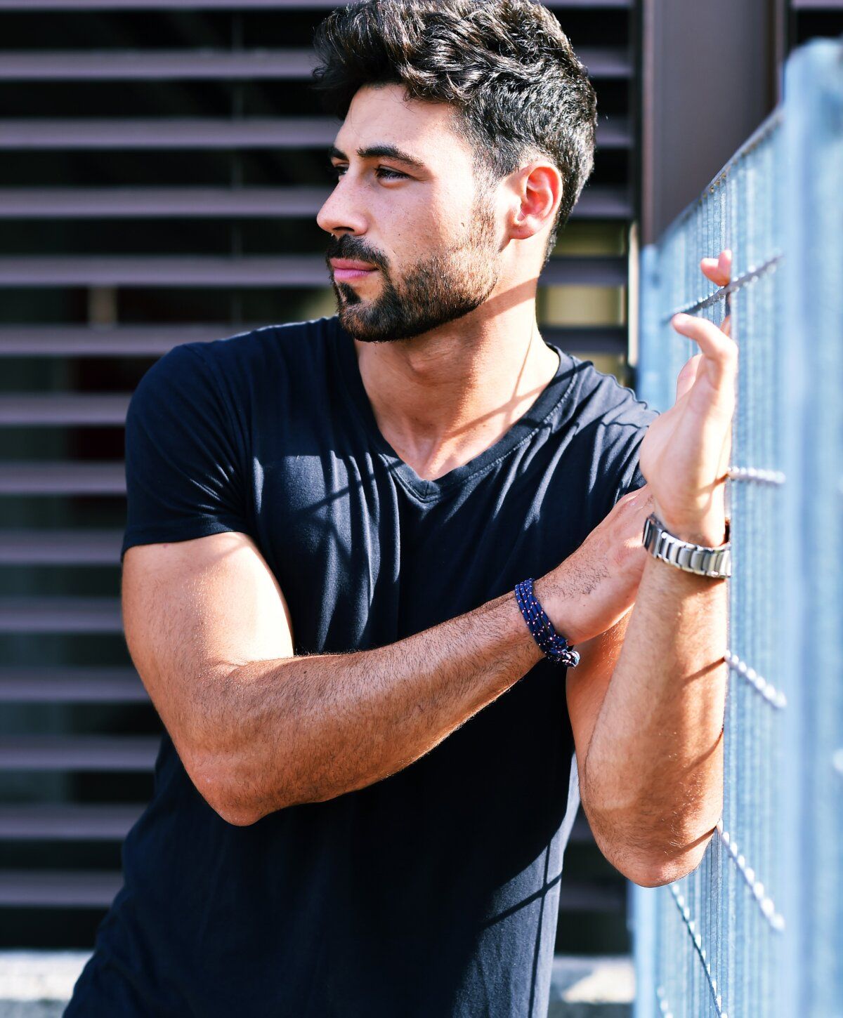 prp hair restoration patient model leaning on a fence looking thoughtfully.