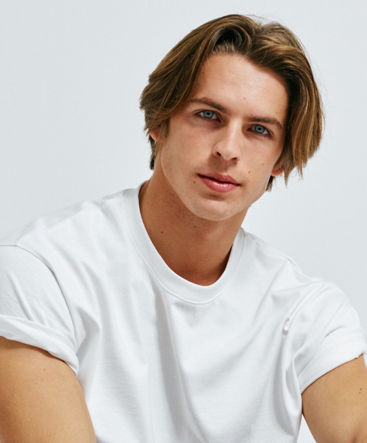 prp hair restoration patient model with tousled hair wearing white t-shirt.