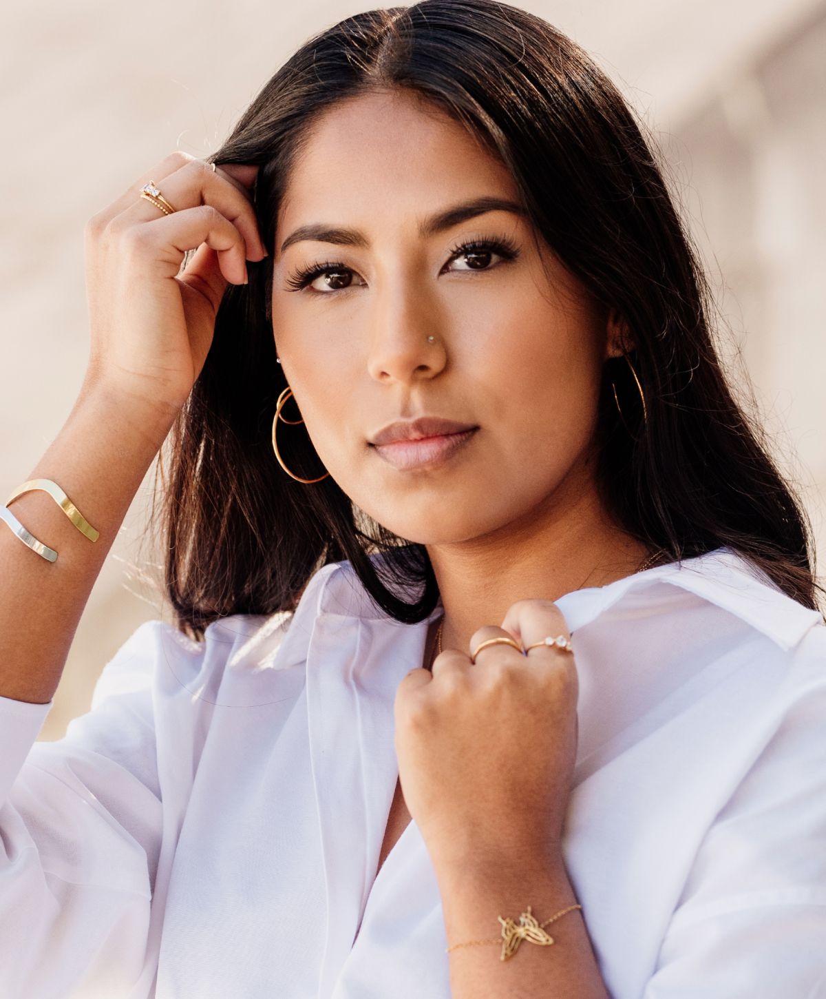 sculptra patient model wearing jewelry and a white shirt.