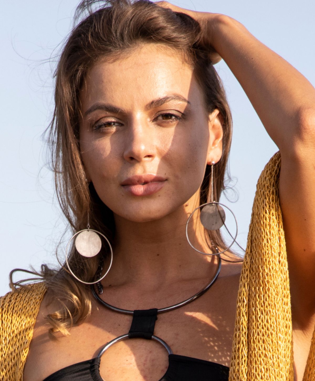 lip filler patient model with earrings and stylish top outdoors.