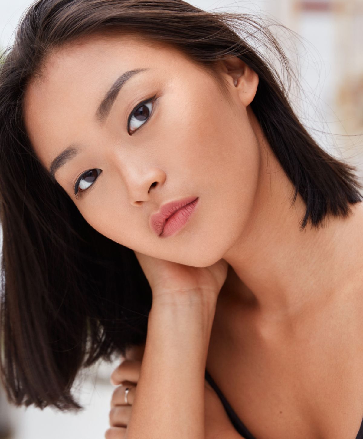 laser hair removal patient model with dark brown hair touching her neck