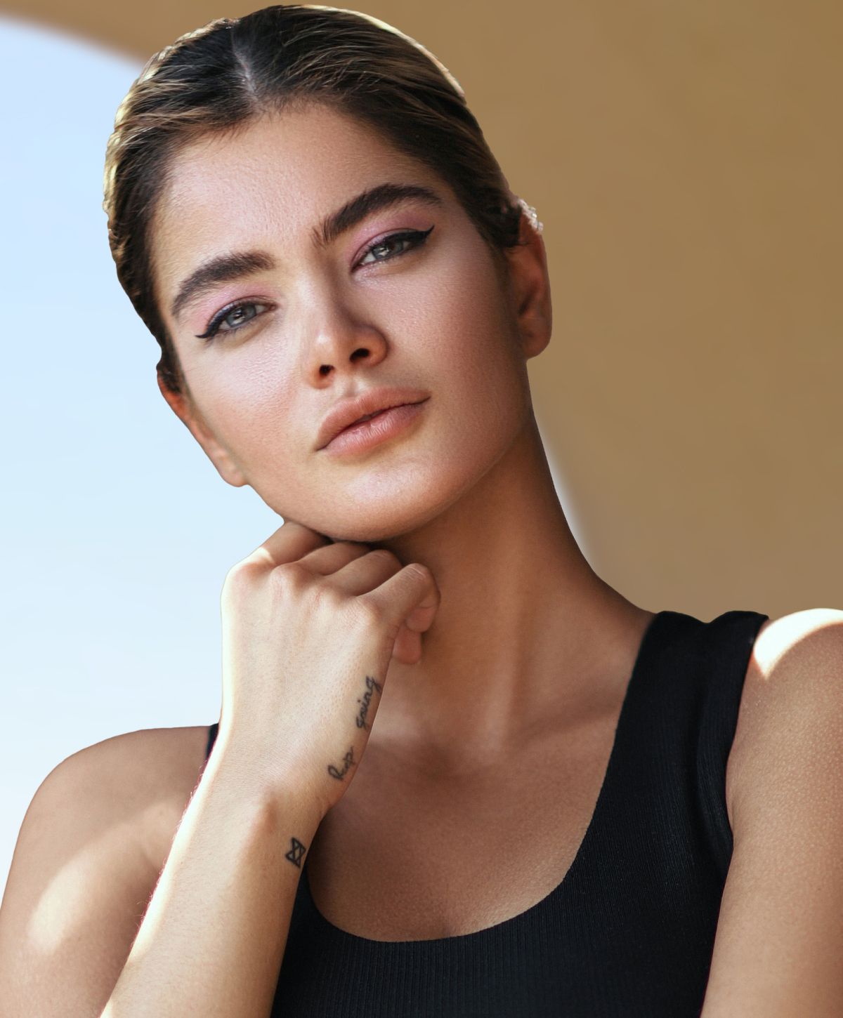 accutite patient model with stylish makeup and tattoos, thoughtful pose.