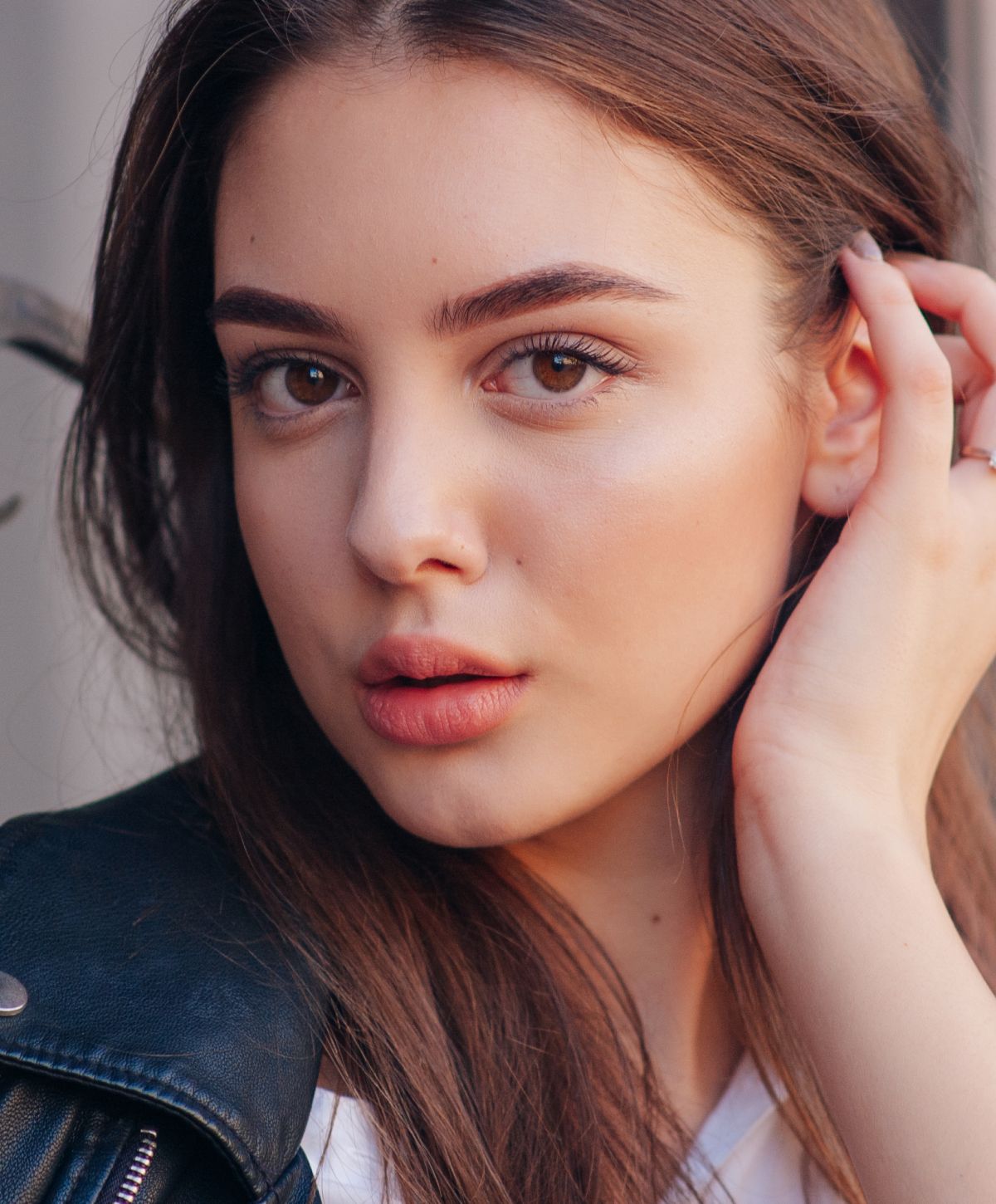 neogen plasma resurfacing patient model with slightly pursed lips pushing her hair behind her ear with her fingers