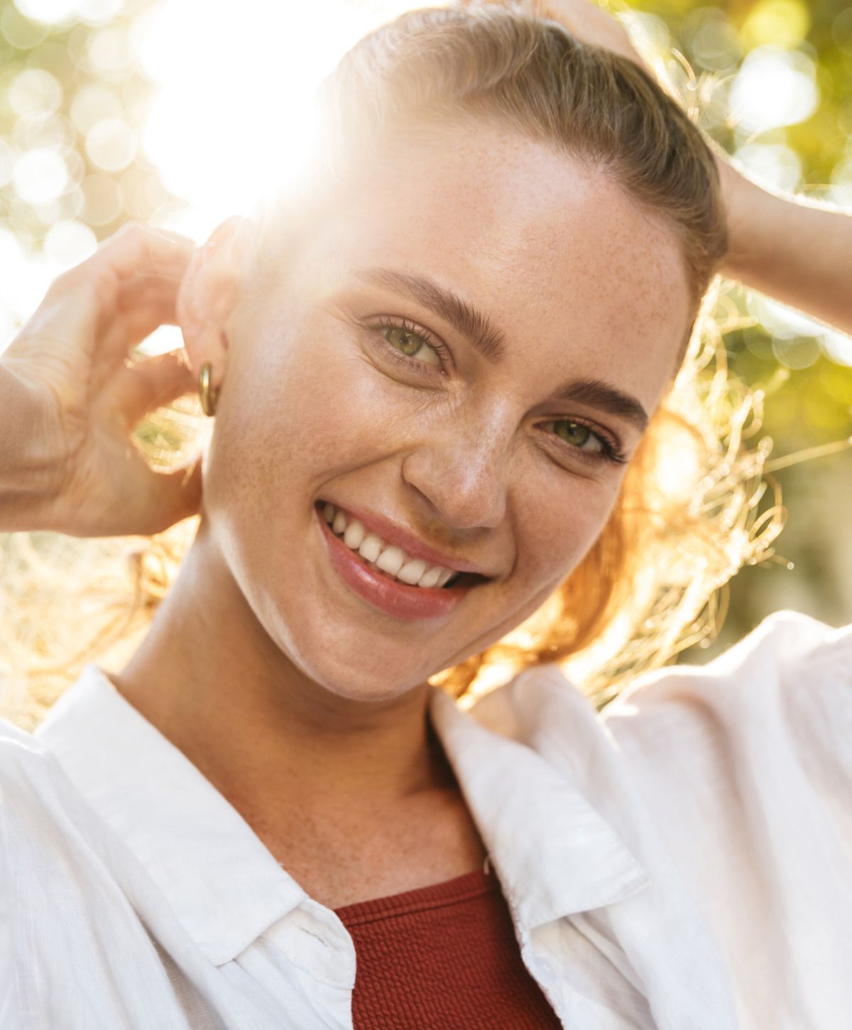 Smiling morpheus8 patient model enjoying natural sunlight outdoors.