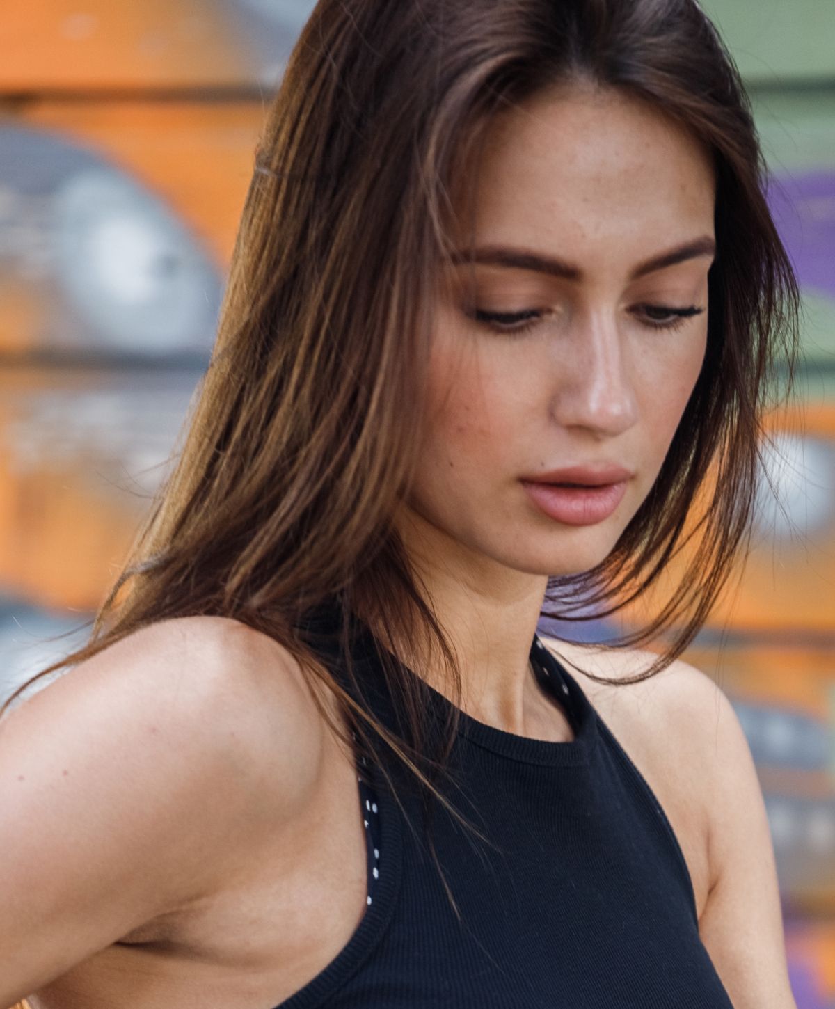 laser tattoo removal patient model with brown hair in a black tank top.