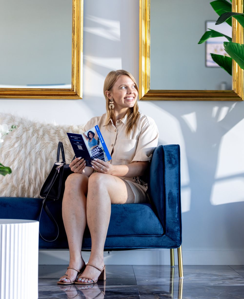 Woman reading on a blue sofa in sunlight.