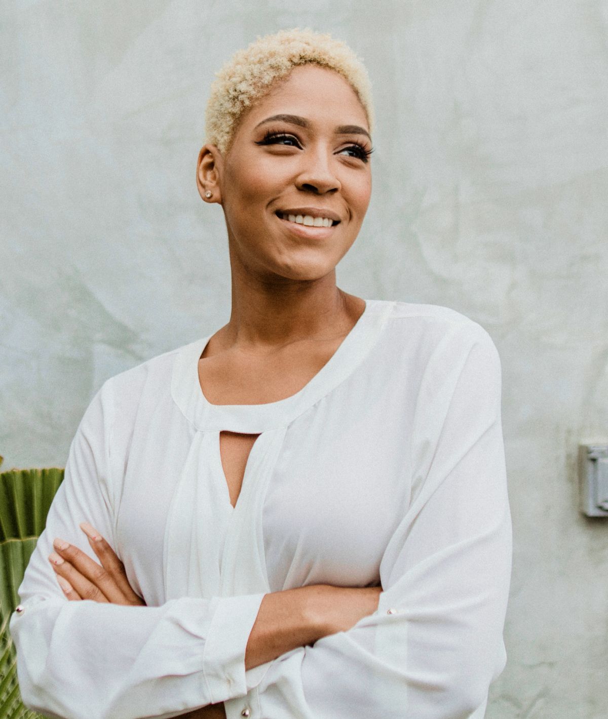 Smiling botox patient model in white shirt against gray background.