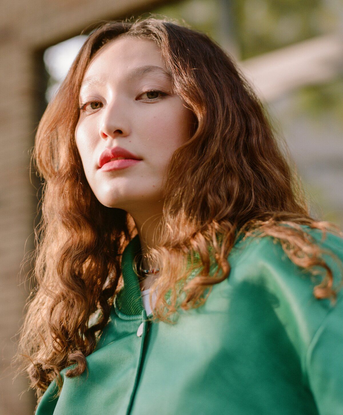 Boynton beach microneedling patient model with wavy hear in a green jumper