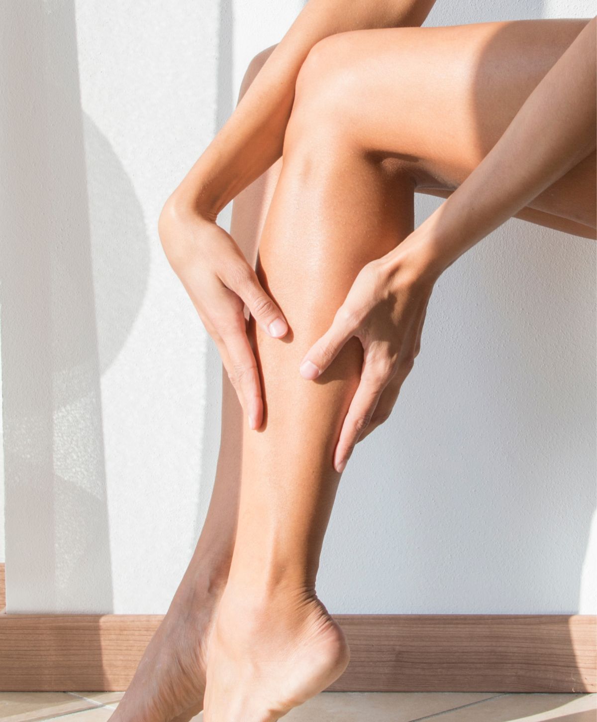 vein treatment patient model gently holding her leg in sunlight.