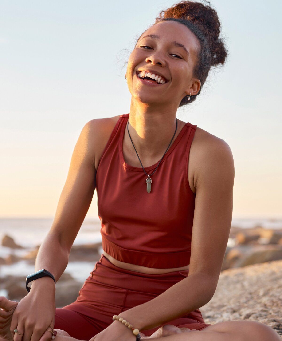 Smiling stomach flu iv therapy patient model in workout attire by the beach.