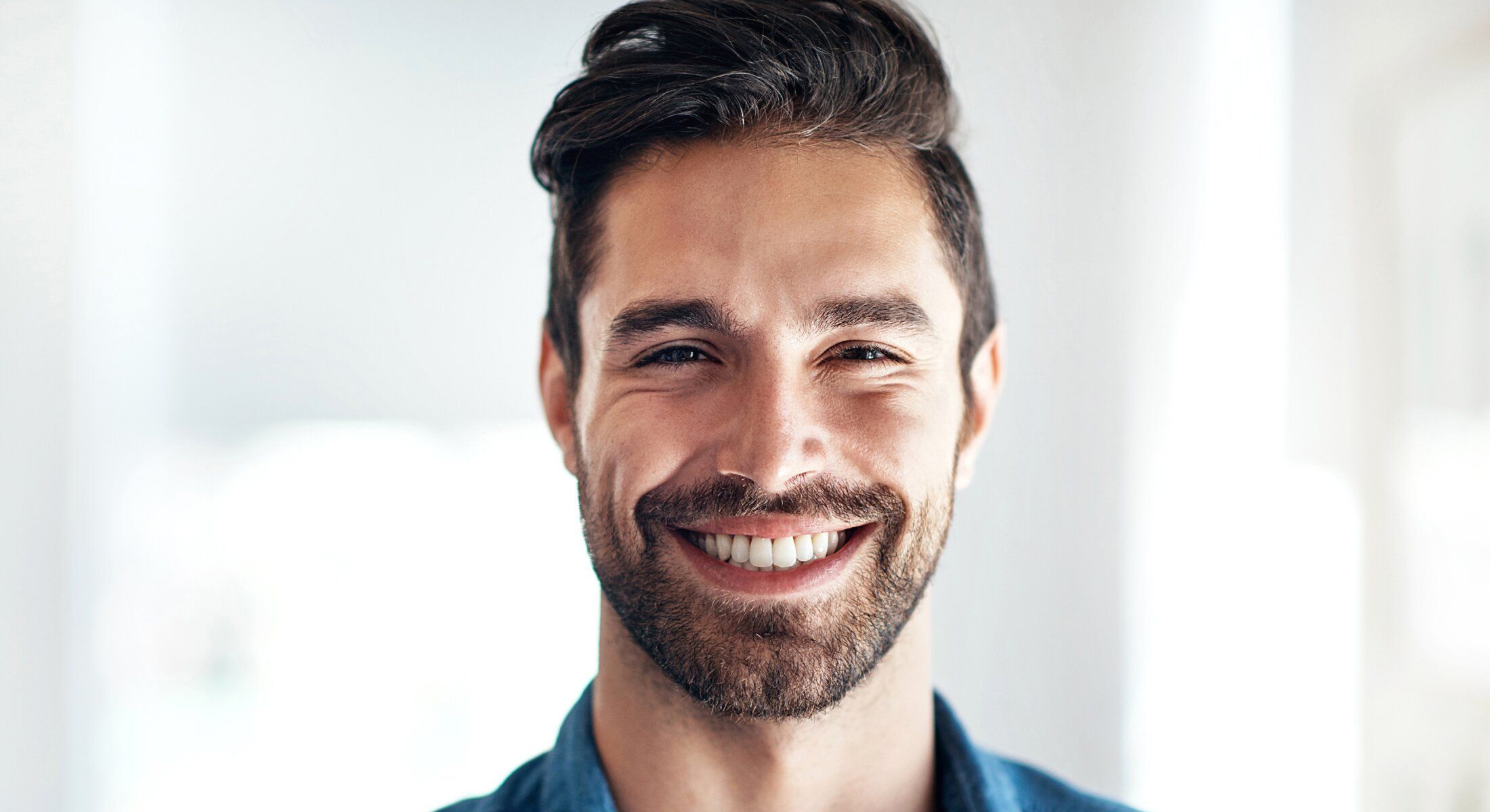 Smiling hair restoration patient model with a beard
