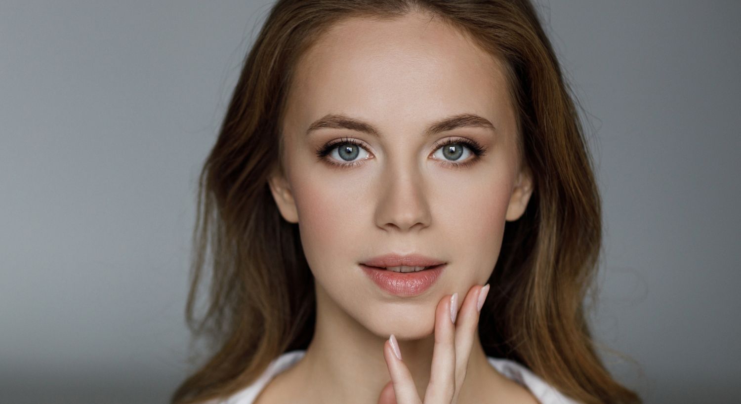 prp skin rejuvenation patient model touching her face and smiling