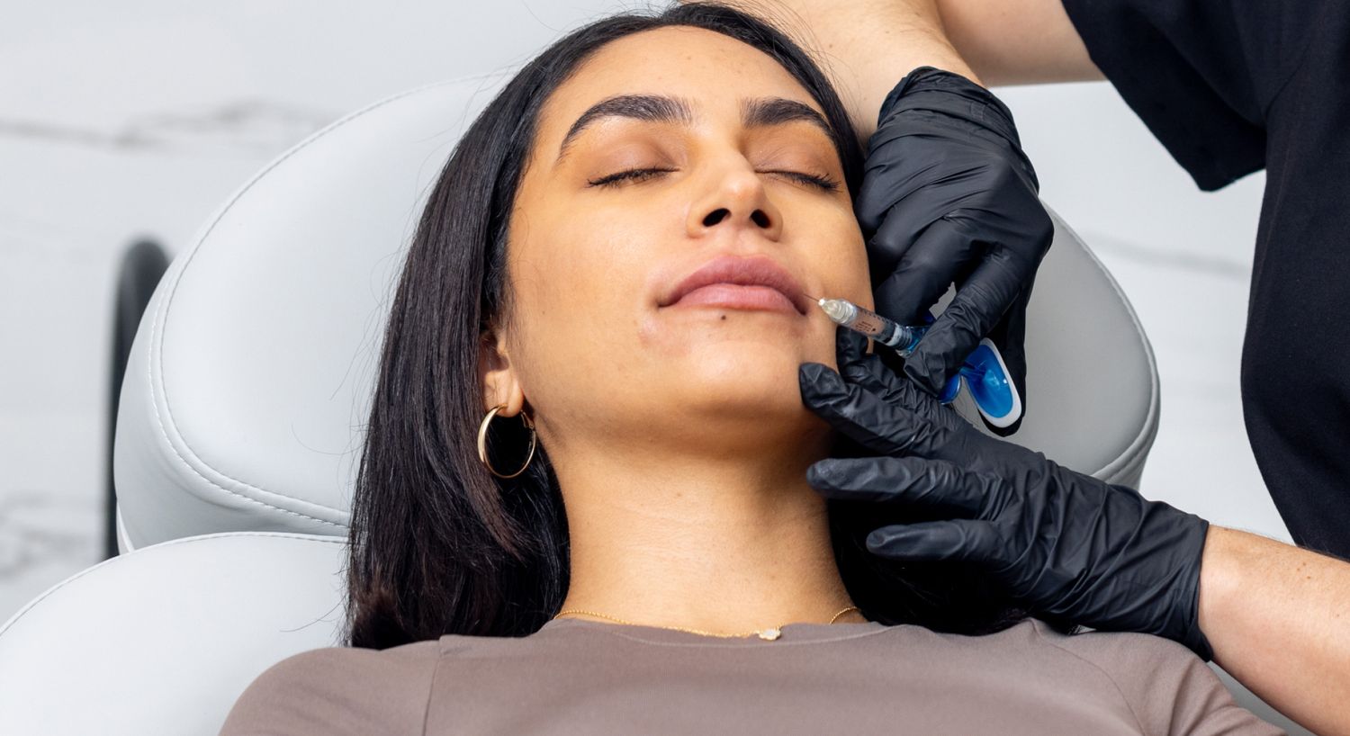 Lip Fillers patient model receiving an injection in her lip