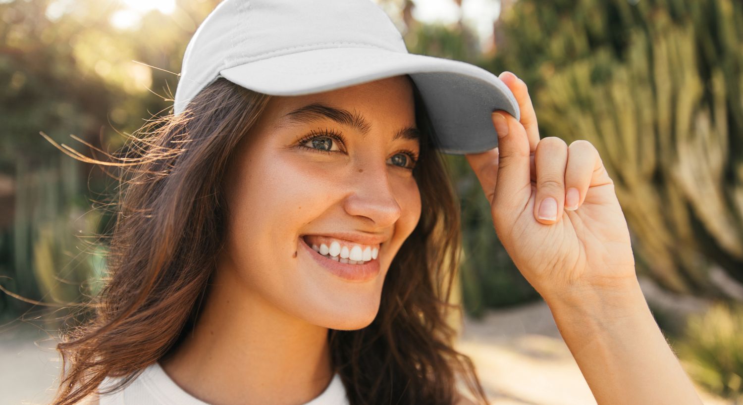 NAD+ IV therapy patient model smiling outside with a light blue baseball hat on