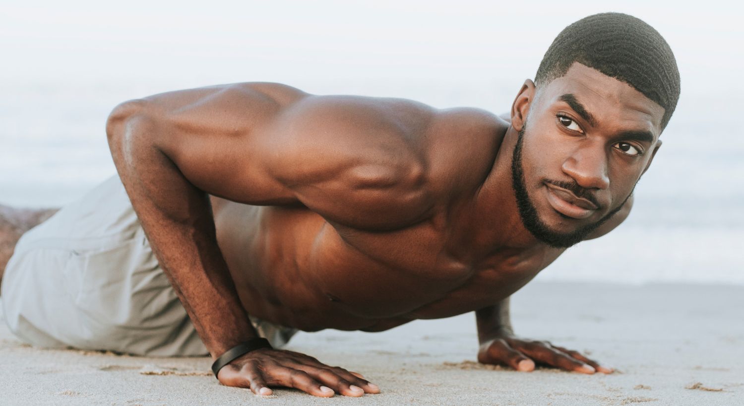 Performance IV therapy patient model doing pushups on a beah