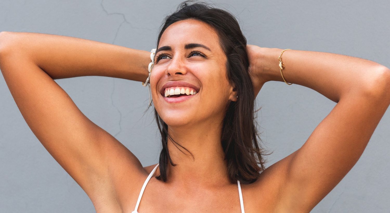 Thread Lift patient model smiling wearing a white bikini top
