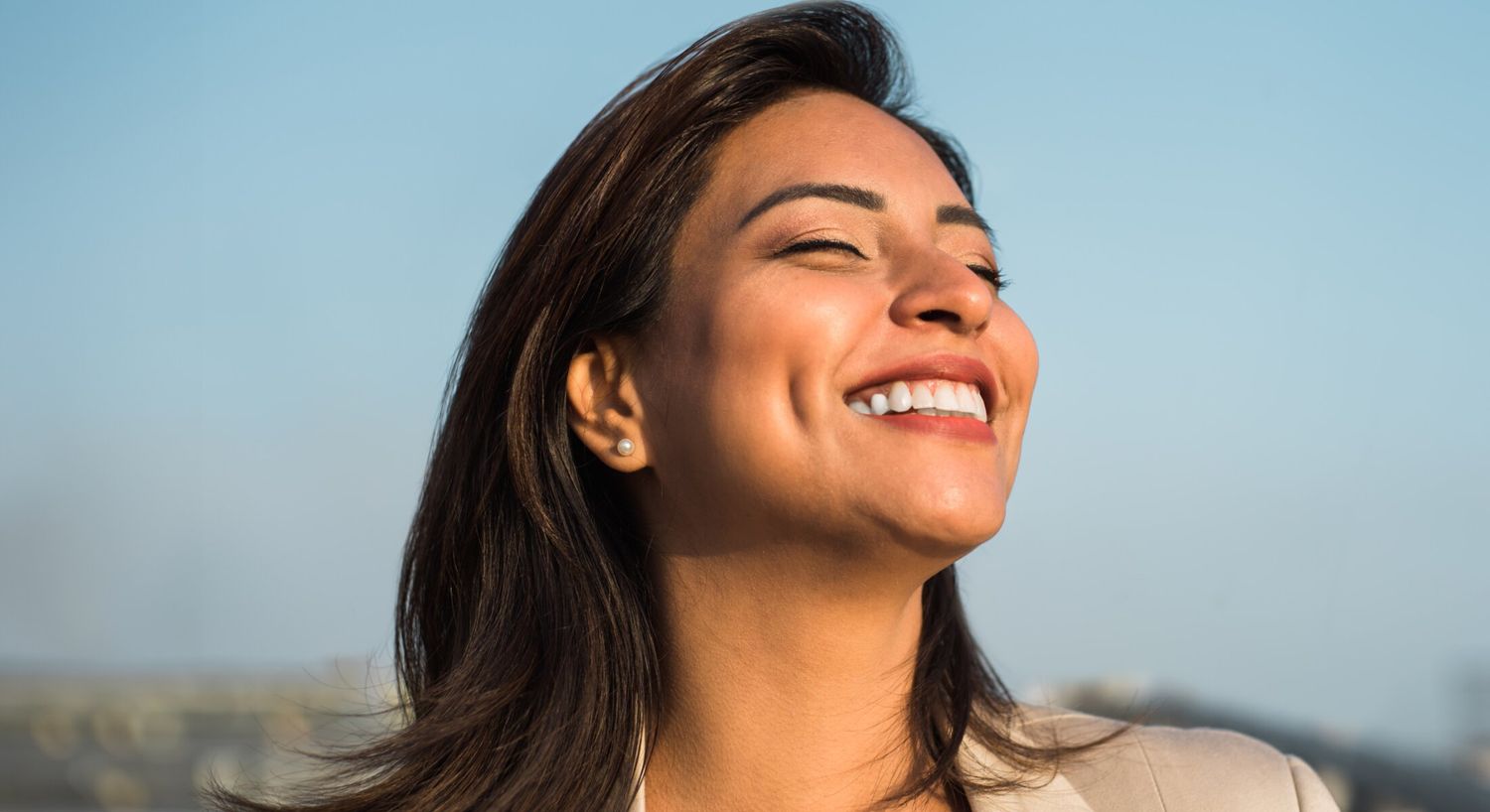Microneedling patient model facing the sun and smiling with her eyes closed