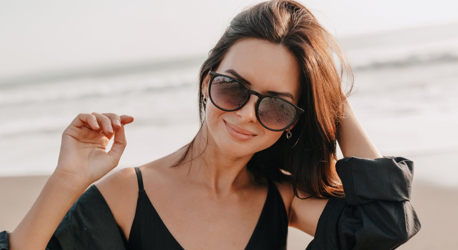 microneedling patient model in sunglasses enjoying a beach day.